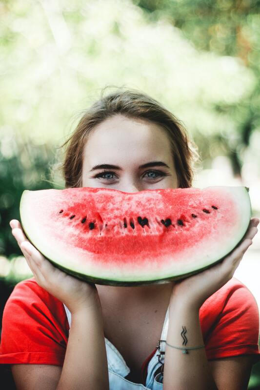 Smiling girl with watermelon showing 
